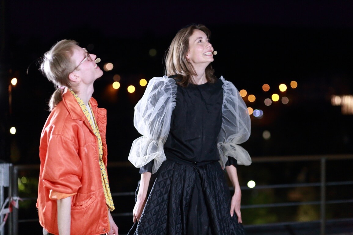 © Peter Schlipf Zwei Personen stehen draußen in der Nacht nebeneinander und schauen lächelnd nach oben